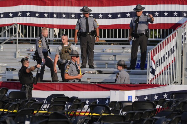 FILE - Law enforcement officers work at the campaign rally site for Republican presidential candidate former President Donald Trump is empty and littered with debris Saturday, July 13, 2024, in Butler, Pa. On Friday, July 19, The Associated Press reported on stories circulating online incorrectly claiming a law enforcement sniper assigned to Trump’s rally says the head of the Secret Service ordered him not to shoot the suspect accused of attempting to assassinate Trump.(AP Photo/Evan Vucci, File)