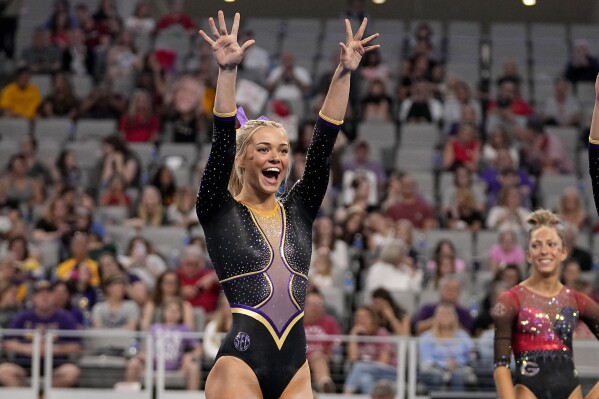 FILE - LSU's Olivia Dunne waves to fans cheering for the team as competitors warm up for the floor exercise during the NCAA women's gymnastics championships in Fort Worth, Texas, Thursday, April 18, 2024. Dunne will return for a fifth season at LSU, saying on social media she’s “not Dunne yet.” (AP Photo/Tony Gutierrez, File)