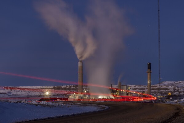 FILE - Taillights trace the path of a motor vehicle at the Naughton Power Plant, Jan. 13, 2022, in Kemmerer, Wyo., next to a site where Bill Gates and his energy company are starting construction on a next-generation nuclear plant. (AP Photo/Natalie Behring, File)