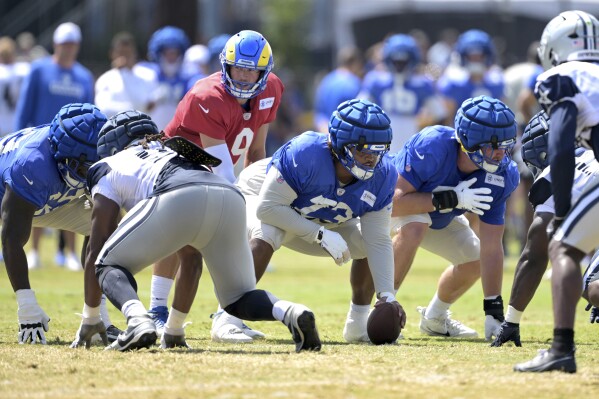 Los Angeles Rams quarterback Matthew Stafford (9) takes the snap from center Steve Avila during a joint practice with the Dallas Cowboys at the Cowboy's NFL football training camp Thursday, Aug. 8, 2024, in Oxnard, Calif. (AP Photo/Jayne Kamin-Oncea)