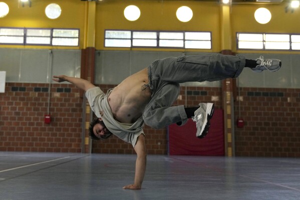 Alexandre Sazy breakdances in a gymnasium at the 2024 Summer Olympics, Tuesday, July 30, 2024, in Paris, France. (AP Photo/Yasin Dar)