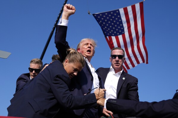 Republican presidential candidate former President Donald Trump is surrounded by U.S. Secret Service agents after an assassination attempt at a campaign rally in Butler, Pa., July 13, 2024. (AP Photo/Evan Vucci)