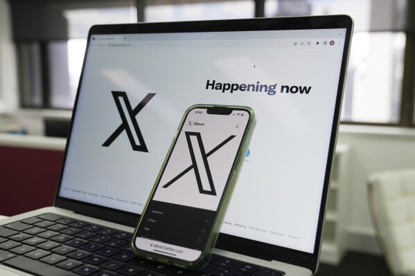 FILE - The opening page of X is displayed on a computer and phone, Oct. 16, 2023, in Sydney. (AP Photo/Rick Rycroft, File)