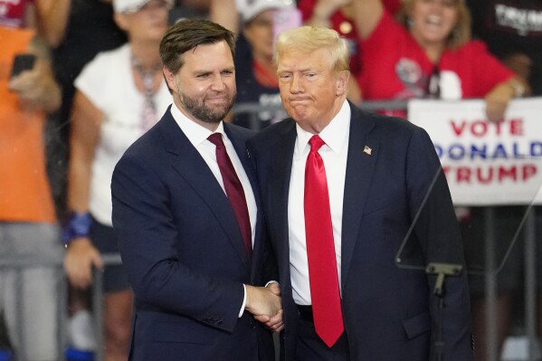 Republican vice presidential candidate Sen. JD Vance, R-Ohio, left, and Republican presidential candidate former President Donald Trump, shake hands at a campaign rally at Georgia State University in Atlanta, Saturday, Aug. 3, 2024. (AP Photo/Ben Gray)