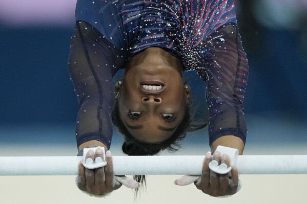 Simone Biles of the United States practices the uneven bars during a gymnastics training session at Bercy Arena at the 2024 Summer Olympics, Thursday, July 25, 2024, in Paris, France. (AP Photo/Charlie Riedel)