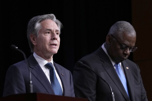 Secretary of State Antony Blinken, left, standing with Defense Secretary Lloyd Austin, right, speaks during a news conference at the United States Naval Academy in Annapolis, Md., Tuesday, Aug. 6, 2024. (AP Photo/Susan Walsh)