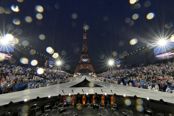 Rain pours down in Paris, France, during the opening ceremony of the 2024 Summer Olympics, Friday, July 26, 2024. (AP Photo/Chris Carlson)