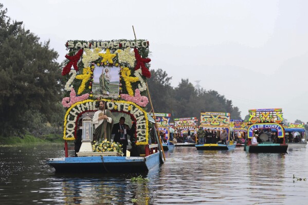 A relic of St. Jude Thaddeus is transported in a glass urn on a trajinera through the canals of Xochimilco, Mexico City, Sunday, Aug. 11, 2024. (AP Photo/Ginnette Riquelme)