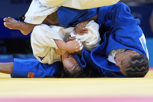 South Korea's Mimi Huh and Brazil's Rafaela Silva, right, compete during their women's 57 kg semifinal match in team judo competition at Champ-de-Mars Arena during the 2024 Summer Olympics, Monday, July 29, 2024, in Paris, France. (AP Photo/Eugene Hoshiko)