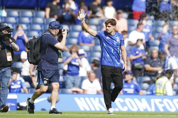 Chelsea's new signing Pedro Neto waves to the crowd during the pre-season friendly match at Stamford Bridge, London on Sunday, Aug. 11, 2024. (Zac Goodwin/PA via AP)