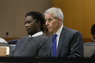 Young Thug, whose real name is Jeffery Lamar Williams, and his lawyer, Brian Steel, watch Judge Ural Glanville speak during the hearing of key witness Kenneth Copeland at the Fulton County Superior Court in Atlanta on June 10, 2024. The judge overseeing the racketeering and gang prosecution against Young Thug and others on Monday, July 1, 2024 put the long-running trial on hold until another judge rules on requests by several defendants that he step aside from the case. (Miguel Martinez/Atlanta Journal-Constitution via AP, file)