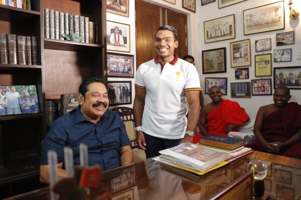 FILE -Sri Lankan Prime Minister Mahinda Rajapaksa sits for photographs, with his lawmaker son Namal by his side, following his election victory in the general election at his residence in Tangalle, Sri Lanka, Aug. 7, 2020. T (AP Photo/Eranga Jayawardena, File)