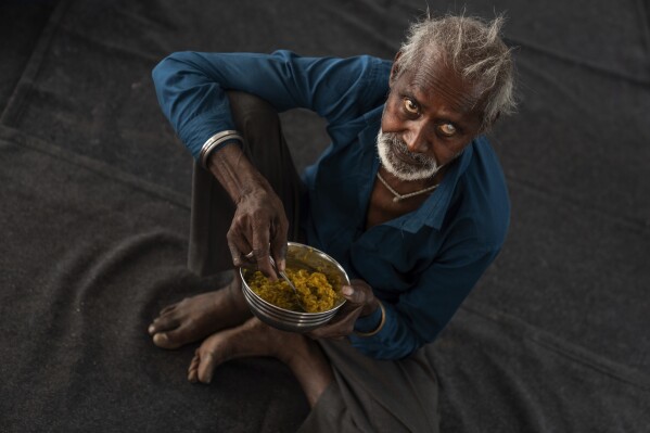 Atmaram, who does not use a surname and was found living on the street a day earlier, eats breakfast at Saint Hardyal Educational and Orphans Welfare Society, or SHEOWS, a home for the aged and unwanted, Friday, April 12, 2024, in New Delhi, India. Some clues about Atmaram's past drip out in the days to come: He used to make clay pots. He and his brother shared a home with their respective wives. His wife died, then his brother. Then, his sister-in-law forced him out. "This house is not yours," he says she told him. (AP Photo/David Goldman)