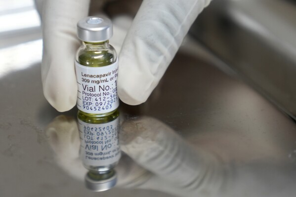 A pharmacist holds a vial of lenacapavir, the new HIV prevention injectable drug, at the Desmond Tutu Health Foundation's Masiphumelele Research Site, in Cape Town, South Africa, Tuesday, July 23, 2024, which was one of the sites for Gilead's lenacapavir drug trial. (AP Photo/Nardus Engelbrecht)