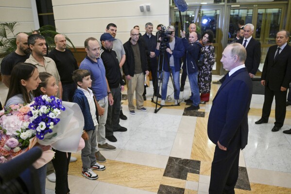 Russian President Vladimir Putin, right, speaks to released Russian prisoners upon their arrival at the Vnukovo government airport outside Moscow, Russia, on Thursday, Aug. 1, 2024. The United States and Russia have made their biggest prisoner swap in post-Soviet history. (Kirill Zykov, Sputnik, Kremlin Pool Photo via AP)