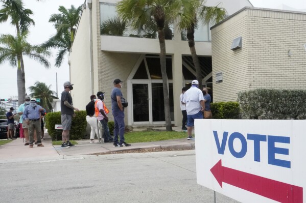 FILE - People wait in line to vote outside of an early voting site in Miami Beach, Fla., Oct. 20, 2020. (AP Photo/Wilfredo Lee, File)