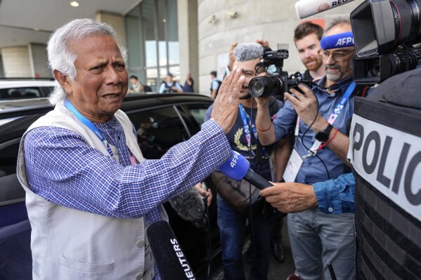 Nobel laureate Muhammad Yunus gestures while speaking to the media upon arriving at Charles de Gaulle's airport in Roissy, north of Paris, Wednesday, Aug. 7, 2024. (AP Photo/Michel Euler)