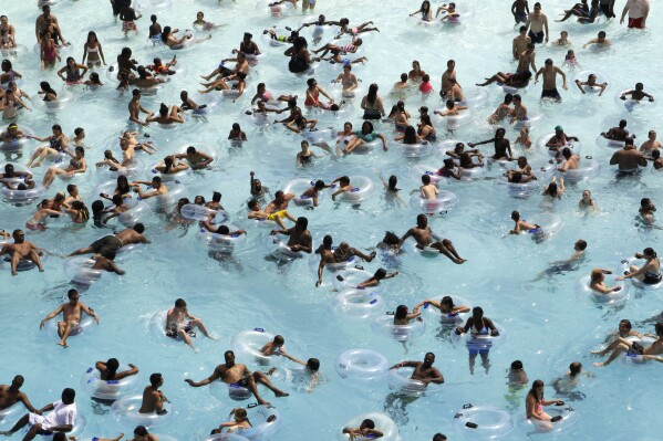 FILE - Swimmers try to stay cool in near 100 degree temperatures at Red Oaks Waterpark in Madison Heights, Mich., June 28, 2012. The Centers for Disease Control and Prevention says drowning is the leading cause of death for children ages 1 to 4. It's also the second leading cause of unintentional death for those ages 5 to 14. (AP Photo/Paul Sancya, File)