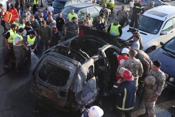 Civil Defense workers extinguish a car that hit by an Israeli strike, in the southern port city of Sidon, Lebanon, Friday, Aug. 9, 2024. (AP Photo/Mohammed Zaatari)