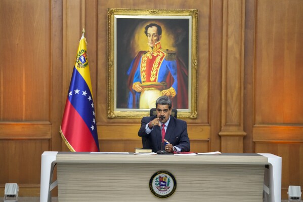 Venezuelan President Nicolas Maduro sits in front of an image of Venezuelan independence hero Simon Bolivar as he gives a news conference at Miraflores presidential palace in Caracas, Venezuela, Wednesday, July 31, 2024, three days after his disputed reelection. (AP Photo/Matias Delacroix)