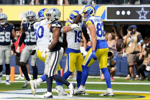 Los Angeles Rams' Logan Bruss (60), Xavier Smith (19) and Miller Forristall (82) celebrate in front of Dallas Cowboys cornerback Josh DeBerry, front, aftger Forristall caught a touchdown pass late in the second half of a preseason NFL football game, Sunday, Aug. 11, 2024, in Inglewood, Calif. (AP Photo/Ryan Sun)