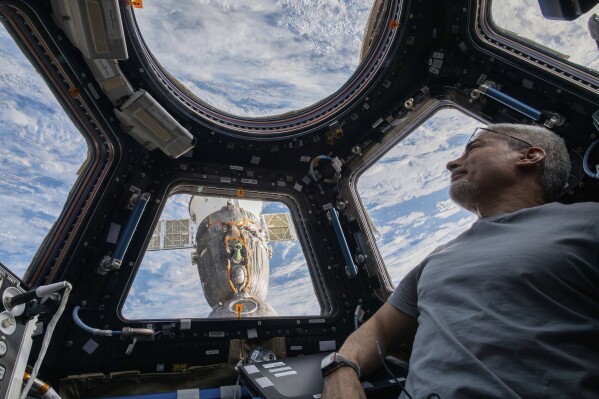 FILE - In this photo provided by NASA, U.S. astronaut and Expedition 66 Flight Engineer Mark Vande Hei peers at the Earth below from inside the seven-windowed cupola, the International Space Station's window to the world on Feb. 4, 2022. (Kayla Barron/NASA via AP, File)