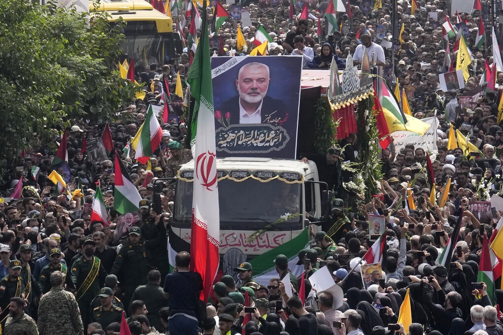 FILE - Iranians follow a truck, center, carrying the coffins of Hamas leader Ismail Haniyeh and his bodyguard during their funeral ceremony at Enqelab-e-Eslami (Islamic Revolution) Sq. in Tehran, Iran, Thursday, Aug. 1, 2024. (AP Photo/Vahid Salemi, File)