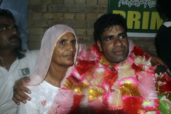 Men's javelin gold medalist, Arshad Nadeem, of Pakistan Arshad Nadeem poses for a photograph with his mother inside his house, in Mian Channu, Khanewal district, of Pakistan, Sunday, Aug. 11, 2024. (AP Photo/Asim Tanveer)