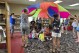 Anita Stevenson, left, leads preschoolers and parents in a parachute game during story time at a public library in Sumter County, Fla., on Aug. 1, 2024. (AP Photo/Mike Schneider)