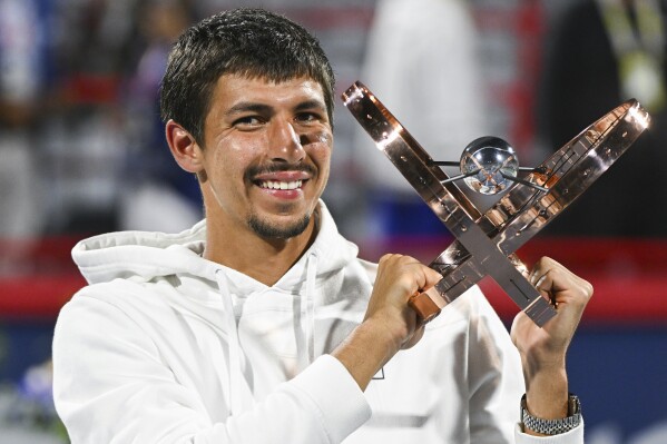 Alexei Popyrin, of Australia, holds up the winner's trophy after defeating Andrey Rublev, of Russia, in the final of the National Bank Open men's tennis tournament in Montreal, Monday, Aug. 12, 2024. (Graham Hughes/The Canadian Press via AP)