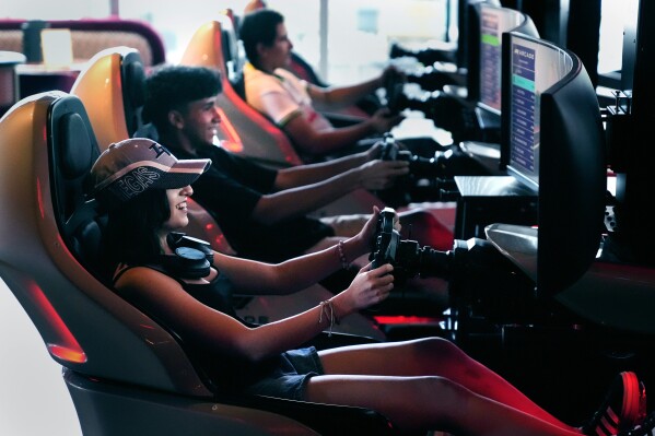 Brianna Restrepo, of Revere, Mass., smiles while racing friends at the F1 Boston Arcade, Monday, July 8, 2024, in Boston. (AP Photo/Charles Krupa)