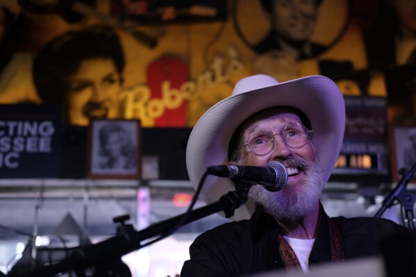 The Rev. Ron Blakely smiles on stage during the Sunday Gospel Hour that he leads at Robert’s Western World honky tonk on Sunday, July 28, 2024, in Nashville, Tenn. (AP Photo/Luis Andres Henao)