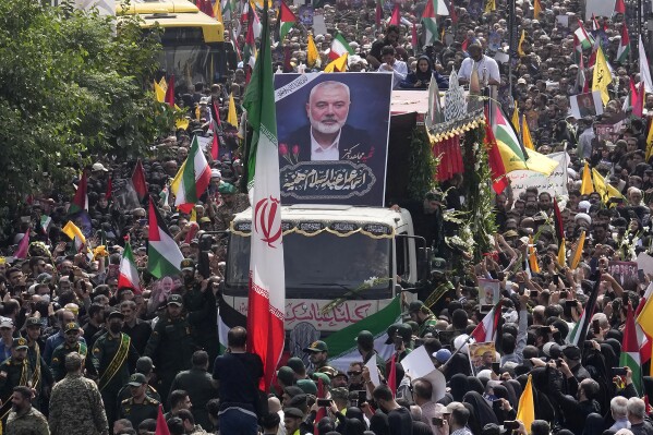 FILE - Iranians follow a truck, center, carrying the coffins of Hamas leader Ismail Haniyeh and his bodyguard during their funeral ceremony at Enqelab-e-Eslami (Islamic Revolution) Sq. in Tehran, Iran, Thursday, Aug. 1, 2024. (AP Photo/Vahid Salemi, File)