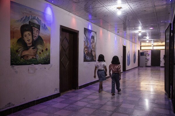 Girls walk through the halls of the children center where they live, which provides a variety of activities for children, northeastern Syria, June 26, 2024. Children at the center include some born to formerly captured Yazidi women. While the Yazidi community has embraced mothers kidnapped by Islamic State group militants, the fate of children born to the women after their capture proved much more contentious. (AP Photo/Baderkhan Ahmad)