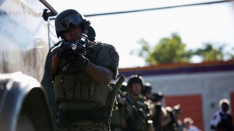 A police officer holds his riot gun in Ferguson, Missouri