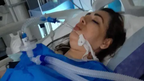 Arezoo Badri being ventilated in a hospital bed