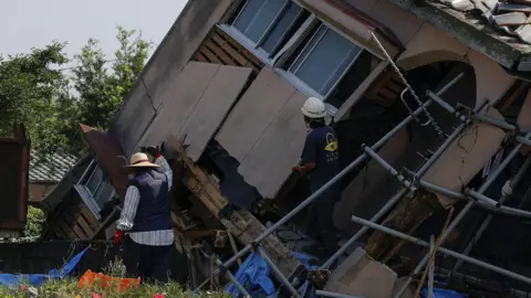 Rescuers work on a house collapsed following an earthquake hit in Osaki town, Kagoshima prefecture, southwestern Japan, August 9, 2024,