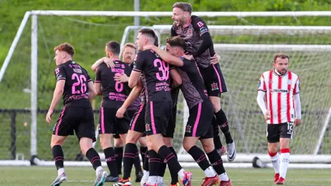 John Mountney is embraced by his Dundalk team-mates after putting the Lilywhites ahead at the Brandywell