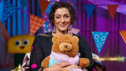 Meera Syal holding a teddy bear 