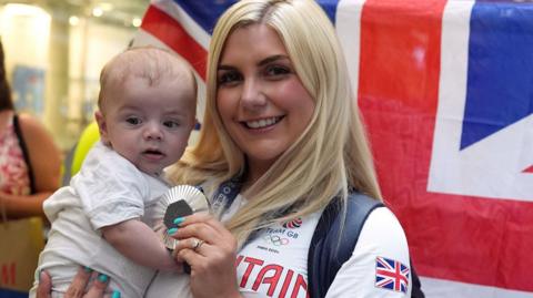 Team GB Olympic silver medallist Amber Rutter with her baby son after arriving back in the UK