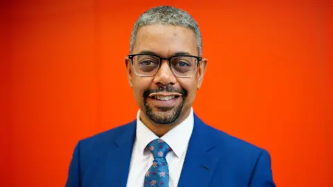 Vaughan Gething smiling while wearing a blue suit