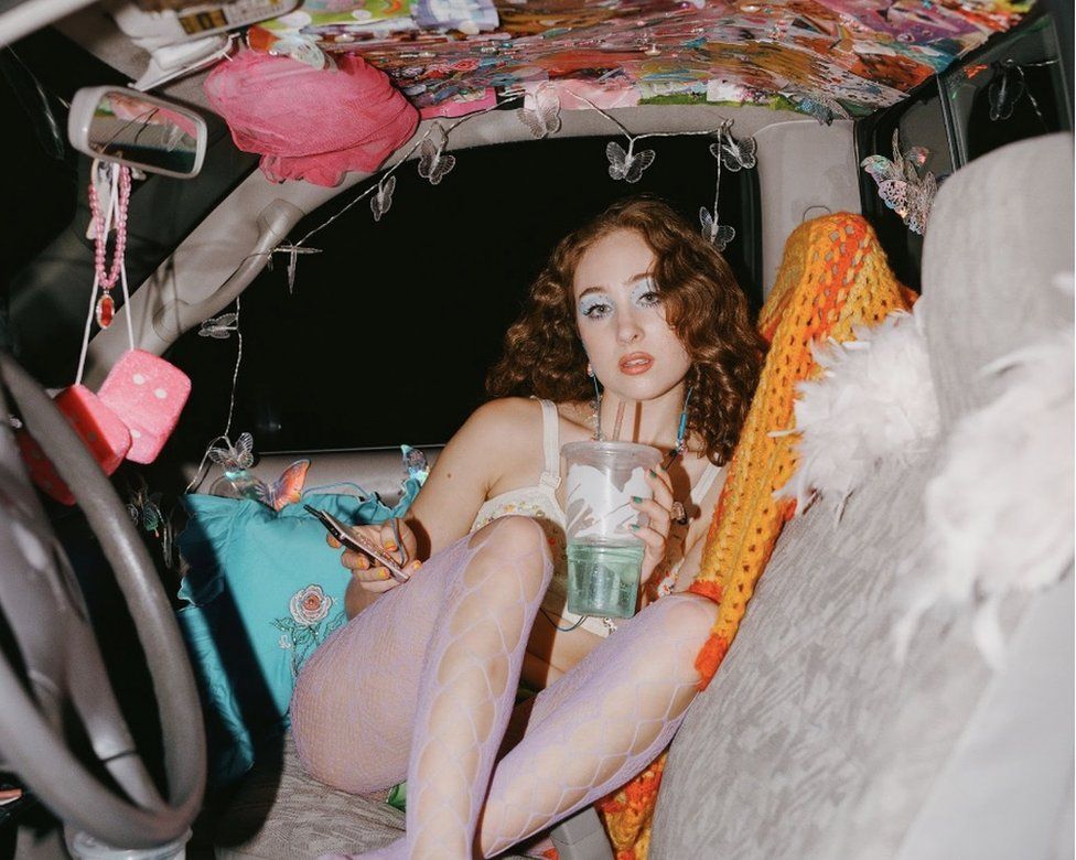 Chappell Roan poses in a 1970s-themed car, in a promotional shot for her single Casual