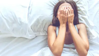 Young woman in bed trying to sleep