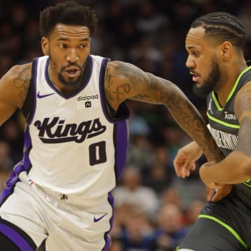 Mar 1, 2024; Minneapolis, Minnesota, USA; Sacramento Kings guard Malik Monk (0) works around Minnesota Timberwolves guard Monte Morris (23) in the first quarter at Target Center. Mandatory Credit: Bruce Kluckhohn-USA TODAY Sports