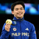 Carlos Yulo smiles while holding up his medal