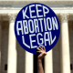 An protester holds a sign that reads, "Keep Abortion Legal"