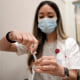 A pharmacist prepares a Moderna Spikevax COVID-19 vaccine.