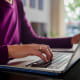 A woman sits at a laptop.