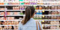 A woman looks at groceries on a shelf