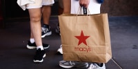 A man is holding Macy's paper bag